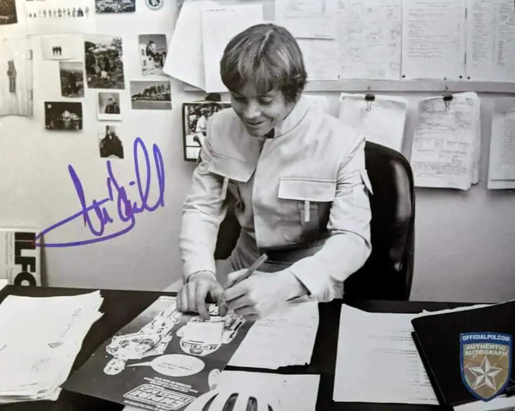 An autographed photo of Mark Hamill signing photos.