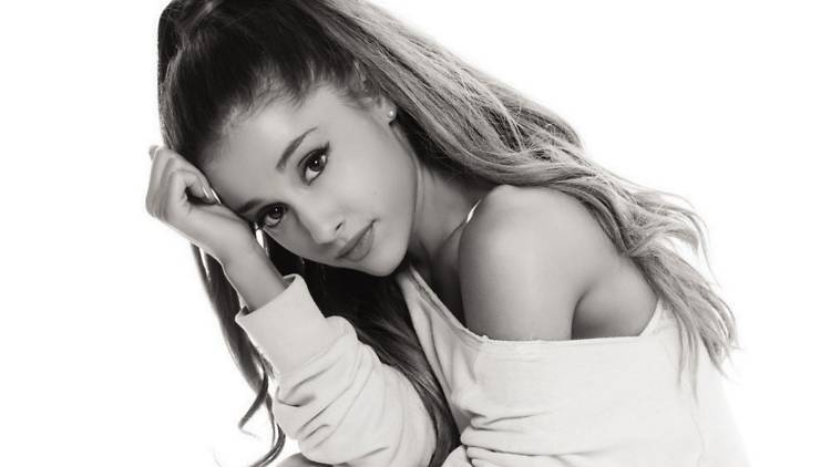 Ariana Grande with her head resting on her closed hand.