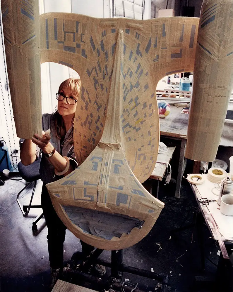 Kim applying tape to the model of the Enterprise.